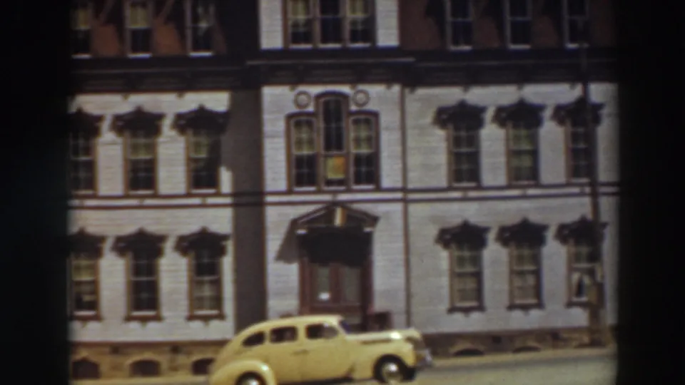 The final frame holds on the ornate Virginia City building and parked yellow car, with wires crossing the sky above the spire.