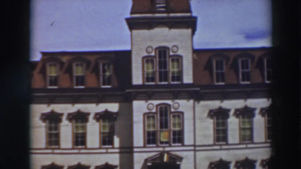 1937 Virginia City frame showing the central tower section, dormers, pale facade, and shadowed entrance canopy.