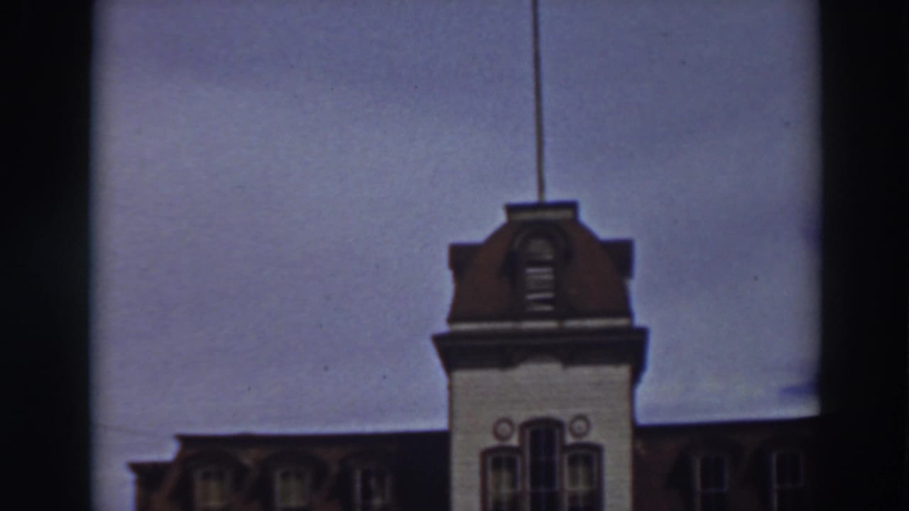 Closer view of the mansion tower and roofline with dark film borders at the sides.