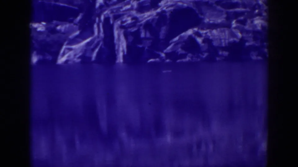 Blue-tinted Angora Lakes shoreline with smooth water, conifers, exposed rocks, and soft 8mm texture.