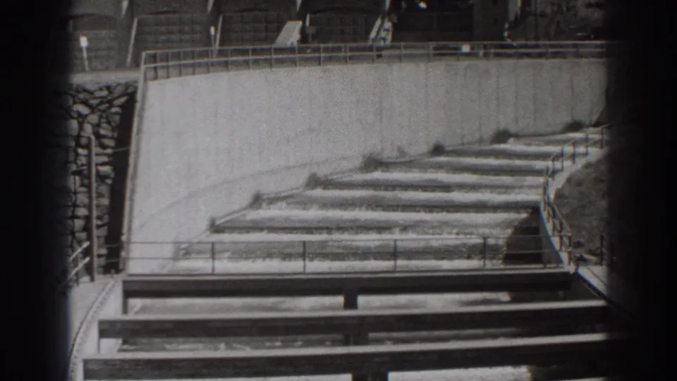 Visitor-shot 1938 view of Bonneville Dam fish-ladder steps, concrete channels, railings, and water flow.
