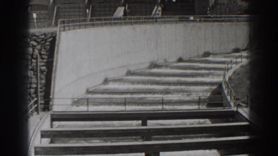 1938 Oregon dam footage showing water flowing through a stepped concrete channel with railings and strong film-edge vignetting.