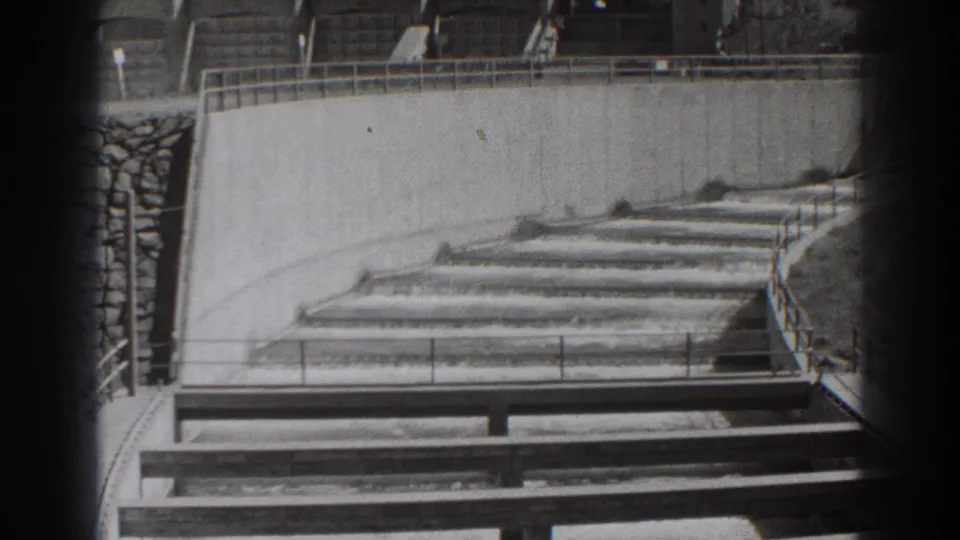 1938 Bonneville Dam footage showing stepped concrete spillway channels and railings from a visitor-style angle.
