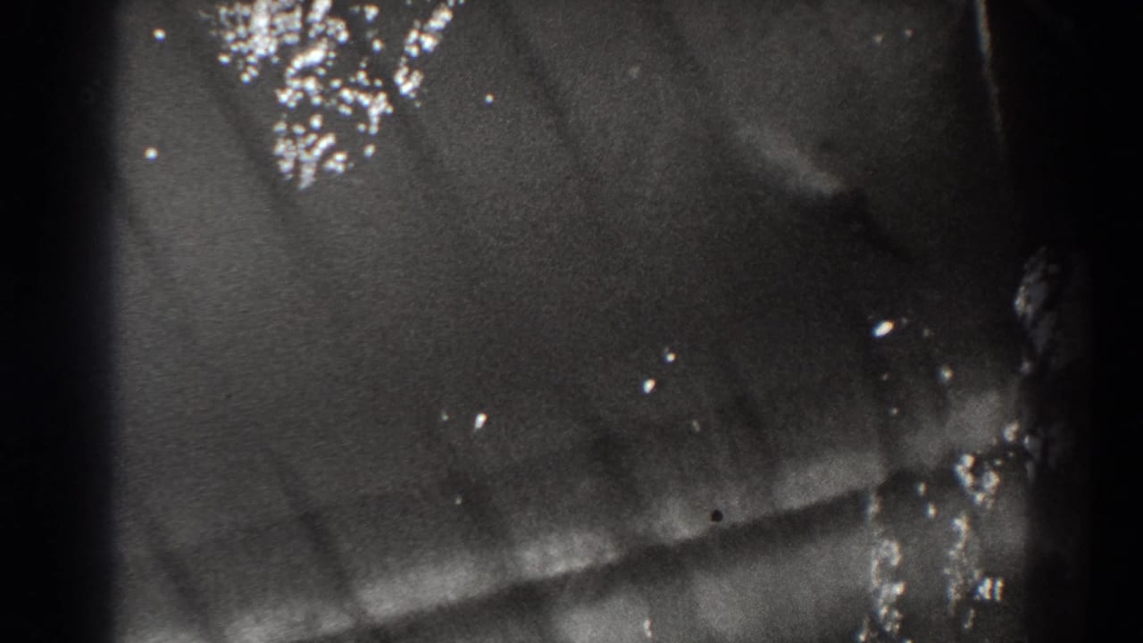 Close view of dark water with bright reflections and soft frame-edge shadowing.