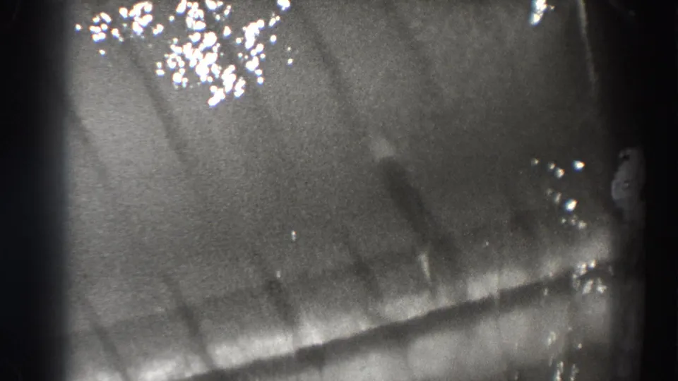 Bonneville Dam water-flow detail with glare, soft distortion, and diagonal movement across the frame.