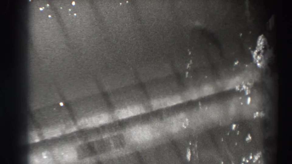 The final frame shows a fish silhouette beneath moving water, bordered by the dark edge of the 8mm scan.