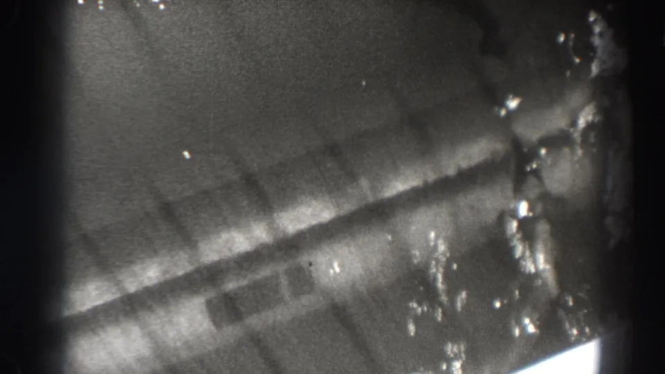 1938 Bonneville Dam footage showing a soft, partial close view of water and structural surfaces framed by dark 8mm gate edges.