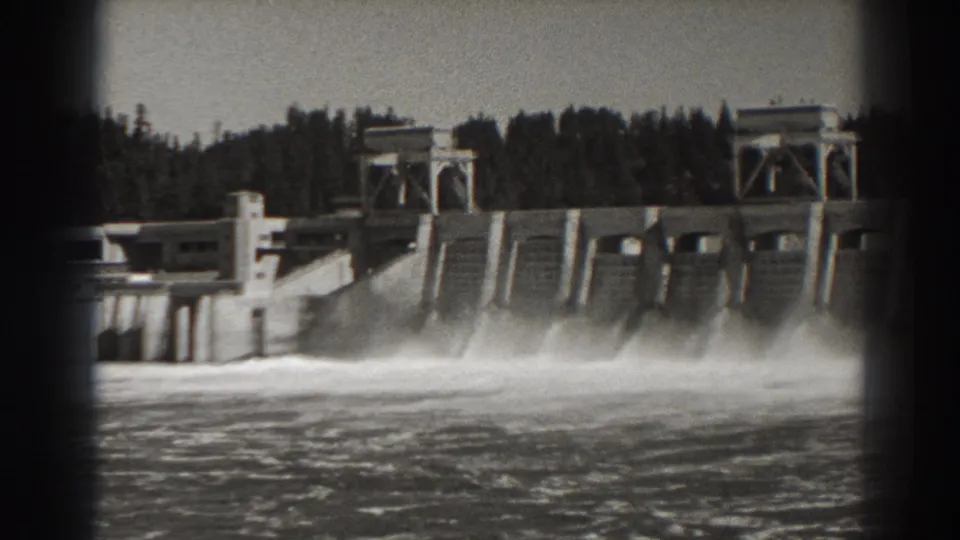 Bonneville Dam in Oregon viewed from across the water, with multiple spillway bays discharging beneath control structures.