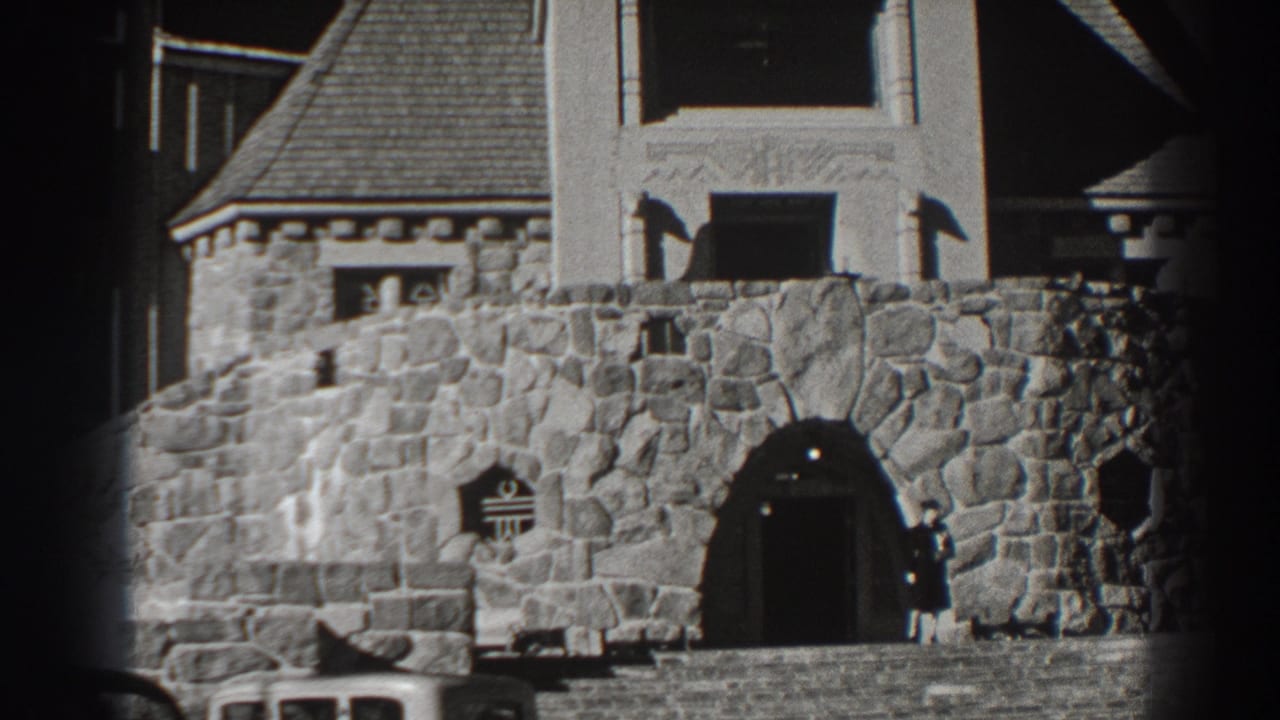 Stone building facade with a person standing near the arched entrance.