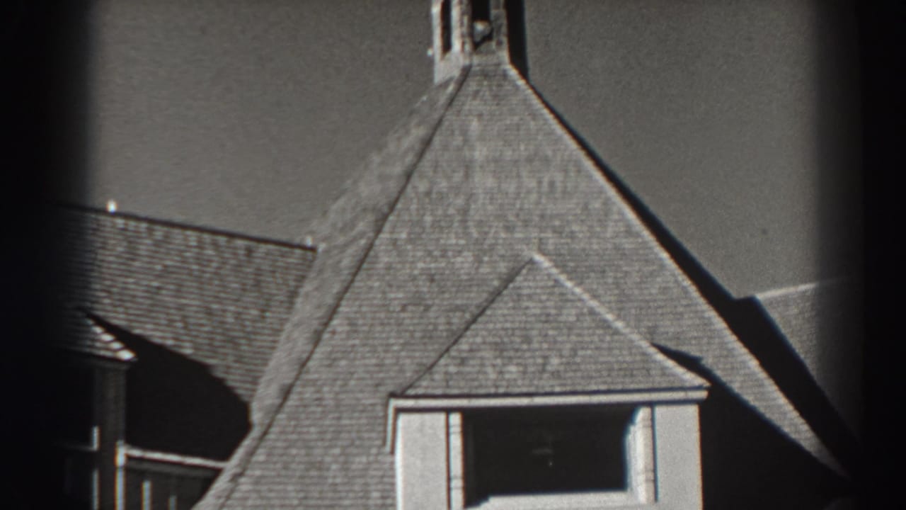 Tight view of the building roofline with a small tower partly visible above it.