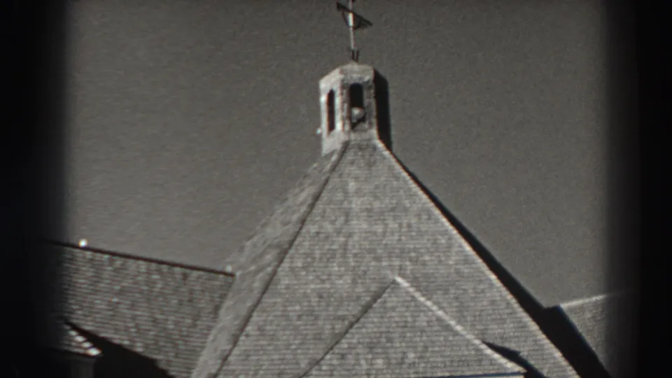 Bonneville Dam building detail from 1938 with a small bell tower, weather vane, steep roof, and adjacent roofline.