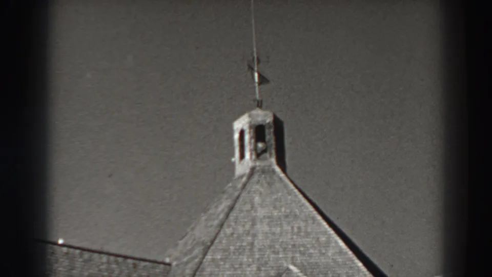 1938 8mm frame from Bonneville Dam, Oregon, showing a cupola roof at left and the flag scene partly entering at right.