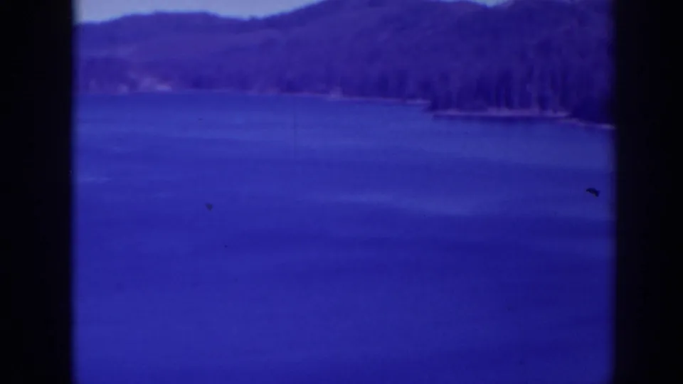 1938 Bucks Lake view across open blue water toward forested hills and a narrow shoreline point.