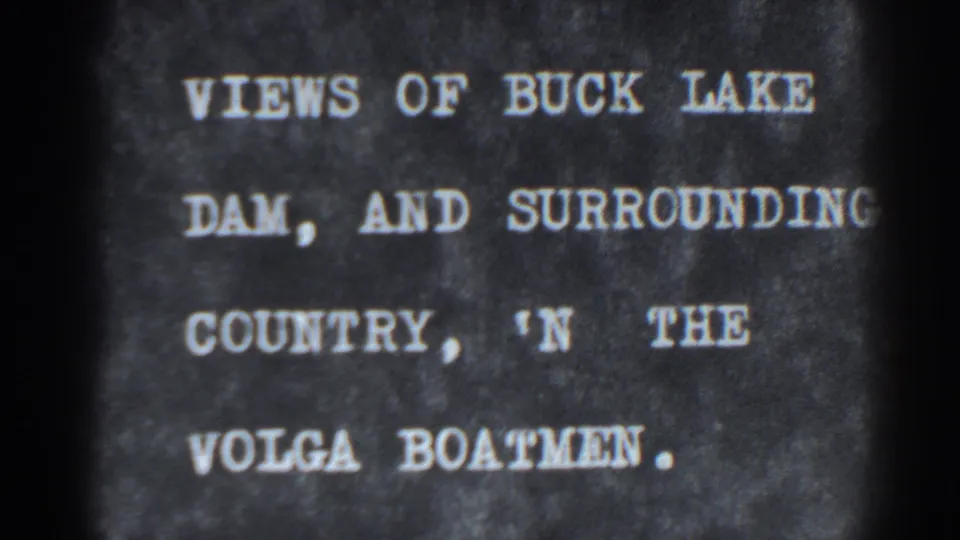 1938 8mm title card for Bucks Lake Dam and surrounding country, shown as white lettering on a dark textured background.
