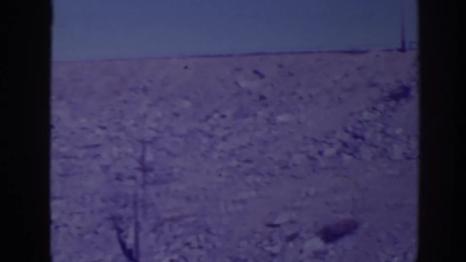 1938 Bucks Lake area frame of an empty rocky slope, distant utility pole, low horizon, and visible 8mm frame borders.