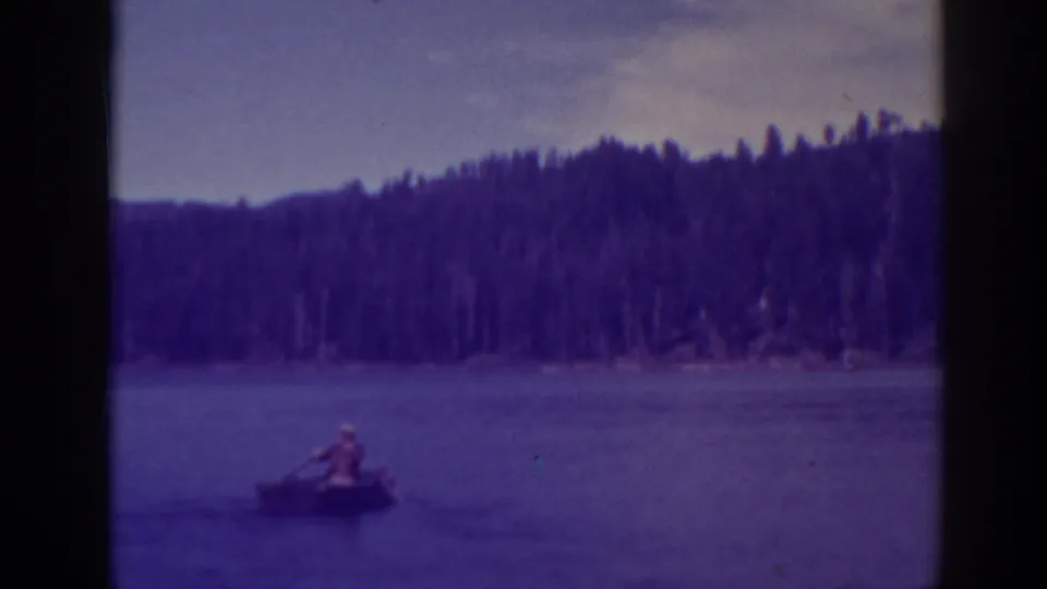 A wider 1938 Bucks Lake view shows the rowboat at a distance, with dense trees and low hills across the water.