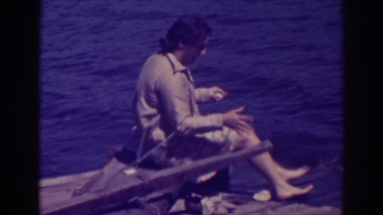 At Bucks Lake in 1938, a woman in a light blouse and floral skirt sits barefoot on a wooden dock near the water.