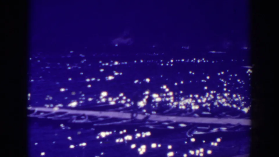 1938 Bucks Lake nighttime home-movie frame with clustered lights across a dark water or shore view.