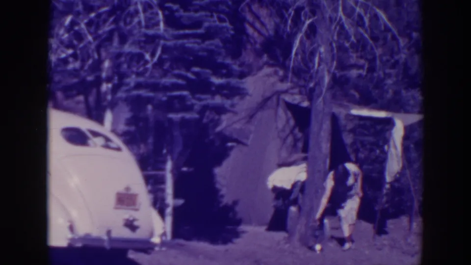 In the final frame, a person bends by the tent entrance in the wooded 1938 Bucks Lake campsite, with the white car at left.
