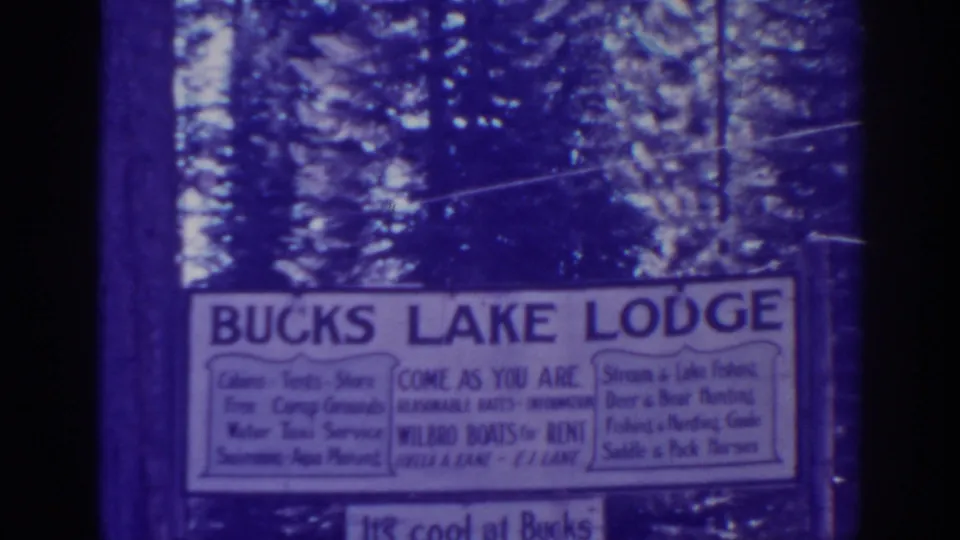 1938 Bucks Lake, California home-movie frame showing a white Bucks Lake Lodge sign among tall pine trees.