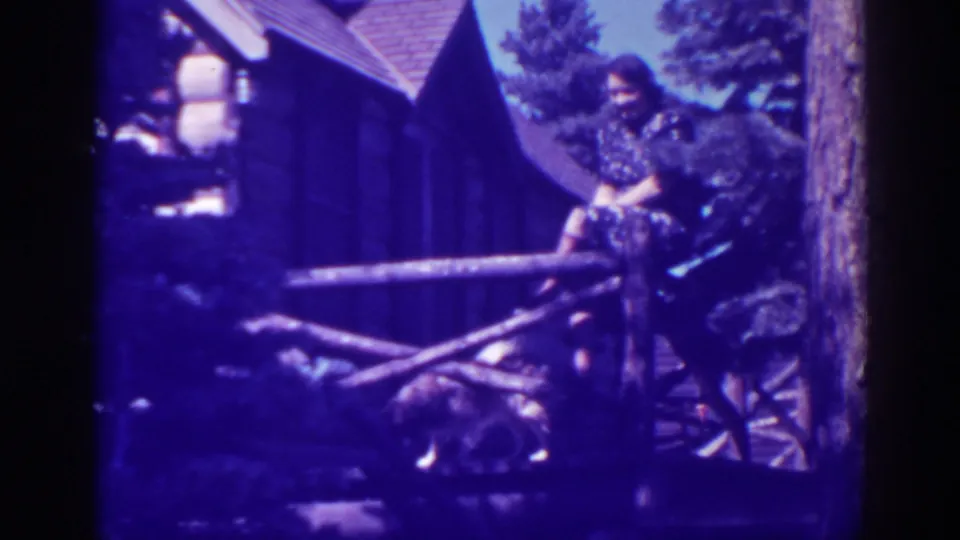 The 1938 Bucks Lake frame shows the woman sitting casually by the cabin porch rail while the dog remains below.