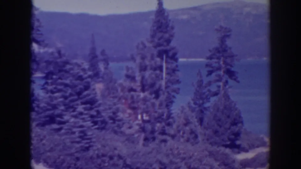 The pan continues across dense evergreens and brush toward Bucks Lake and the wooded hills behind it.