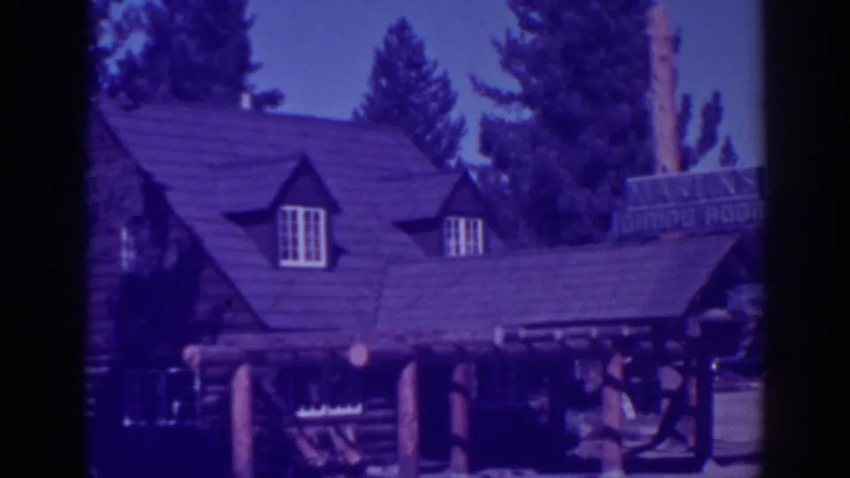 Rustic restaurant exterior in El Dorado City, California, showing log walls, steep roofline, dormer windows, porch posts, and a dining room sign.