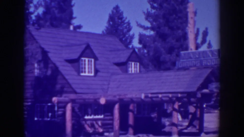 El Dorado City, California restaurant exterior from 1938, showing a log cabin facade, shingled roof, dormer windows, porch posts, and dining room sign.