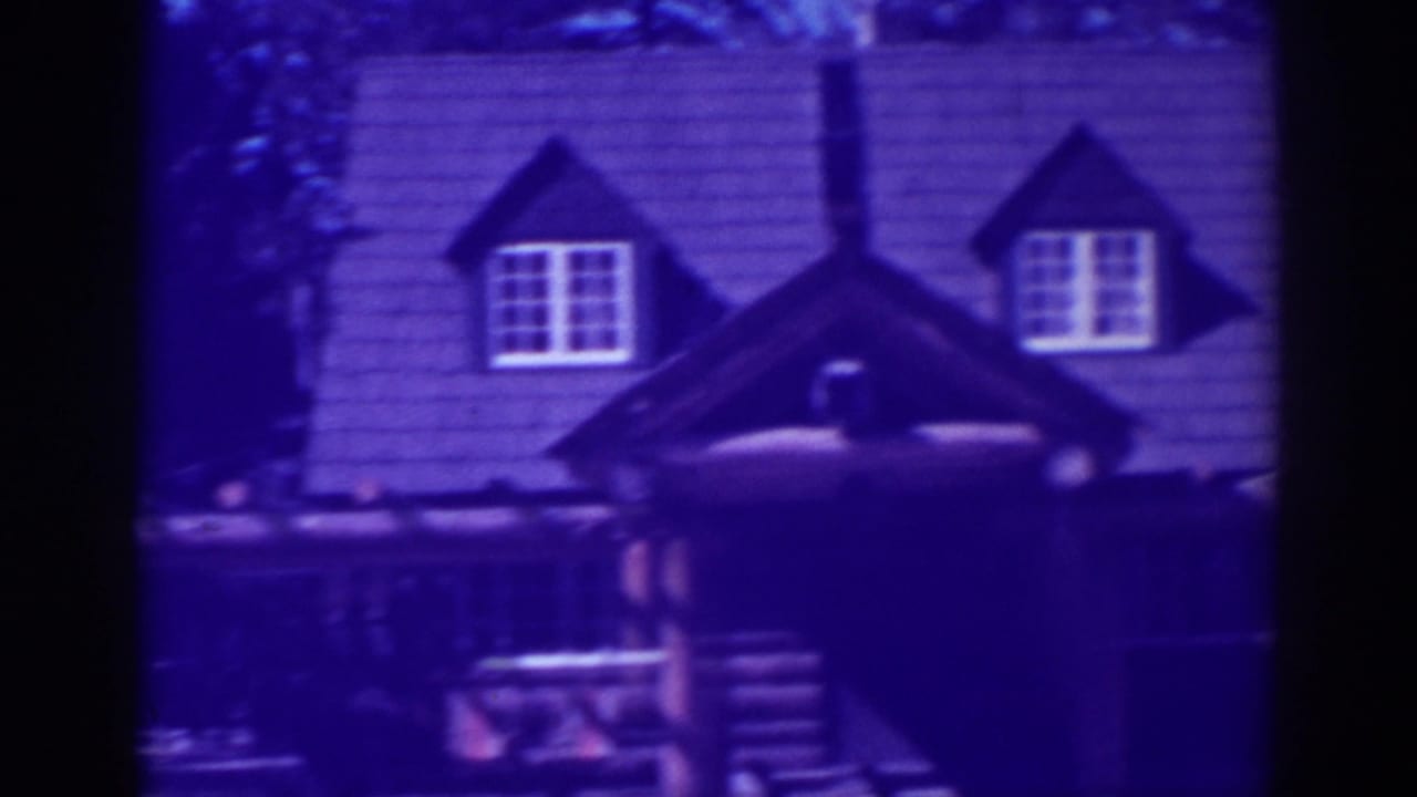 Rustic cabin roof and porch seen through dark frame edges.