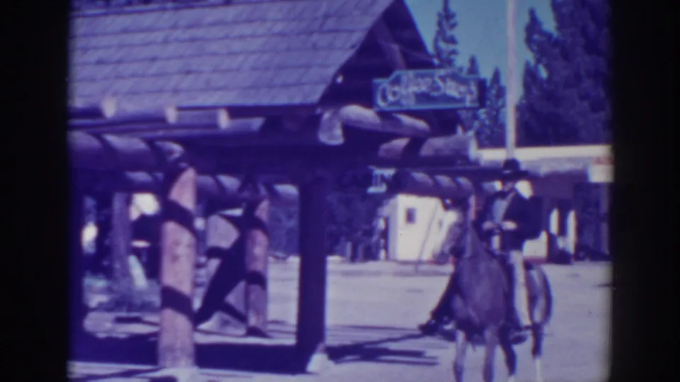 The rider and horse continue across the frame beside log-style posts and a rustic Coffee Shop entrance in the 1938 California home movie.