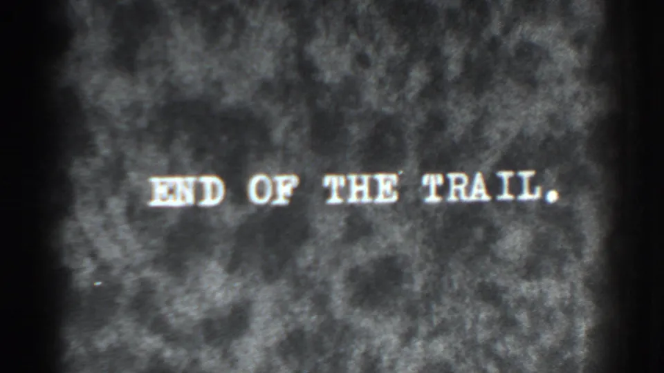 Grainy 8mm end title with white 'END OF THE TRAIL' lettering over a dark textured field.