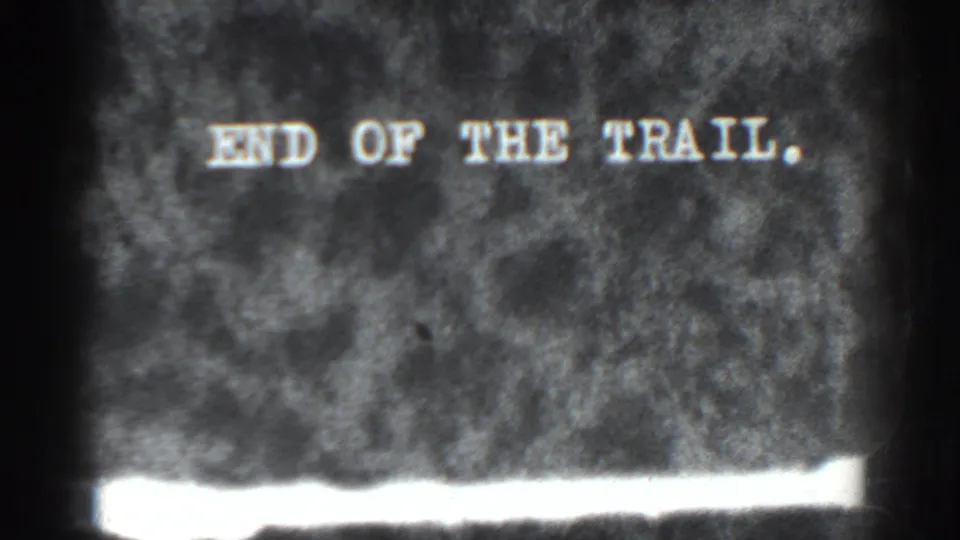 Final 8mm frame of the 'END OF THE TRAIL' card, with a bright exposed band at the bottom.