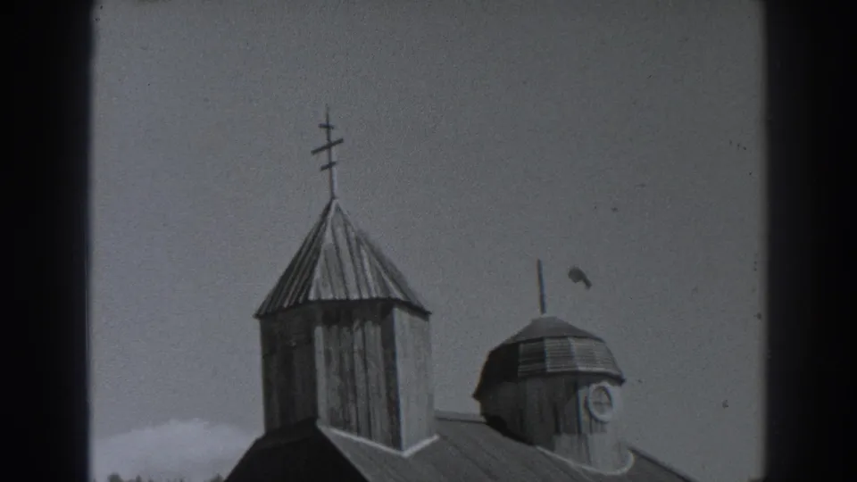 Fort Ross, California 1938 home-movie frame showing the upper roofline, steeple, cross, and domed tower of a wooden church.