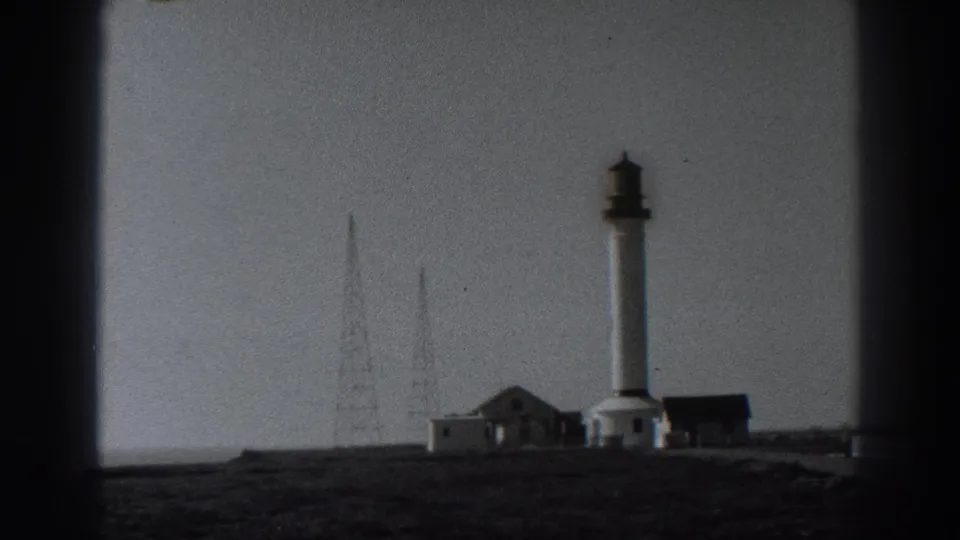 Fort Ross, California frame from 1938 showing a tower, low buildings, radio masts, and open ground, framed by dark home-movie borders.