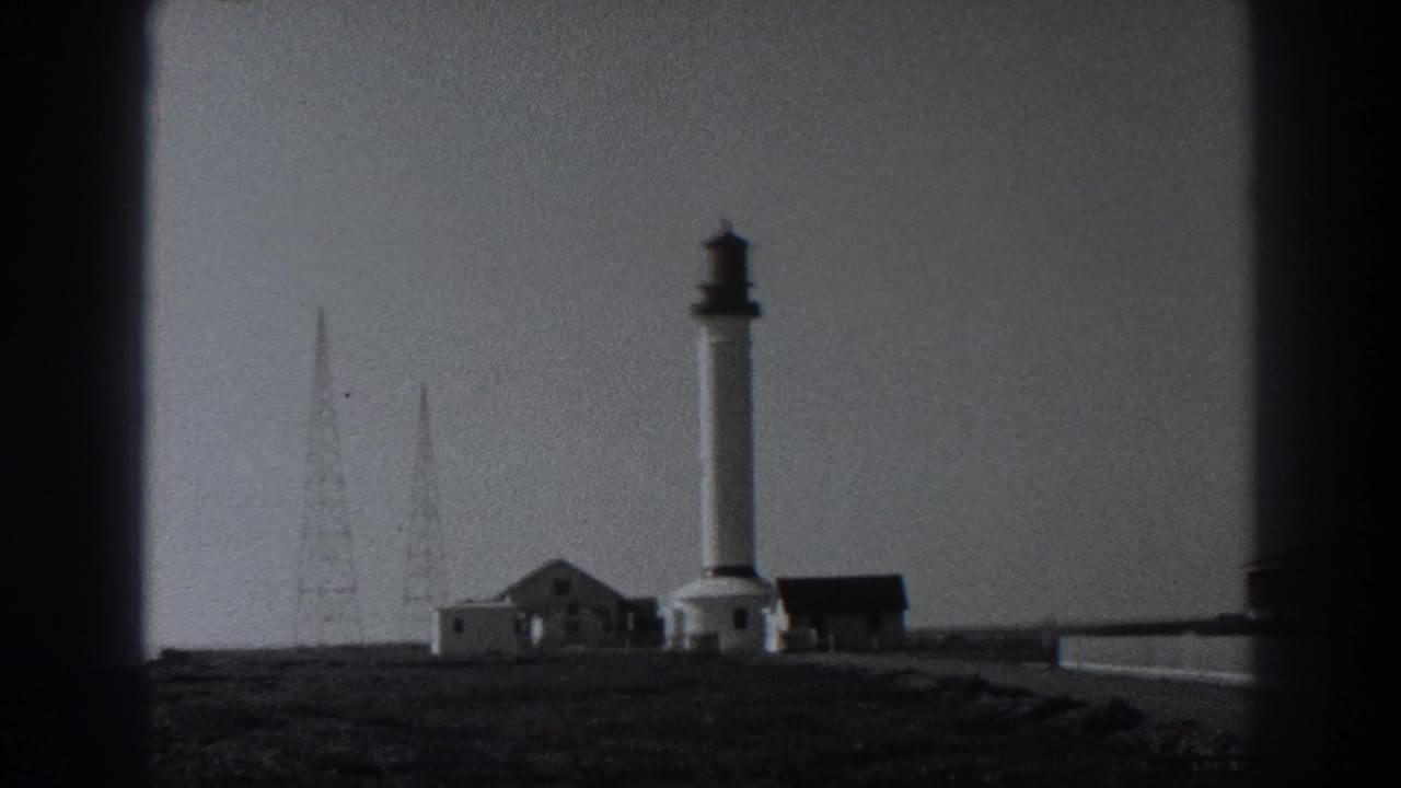 1938 Fort Ross view with the white lighthouse tower, low structures, radio masts, and open coastal ground.