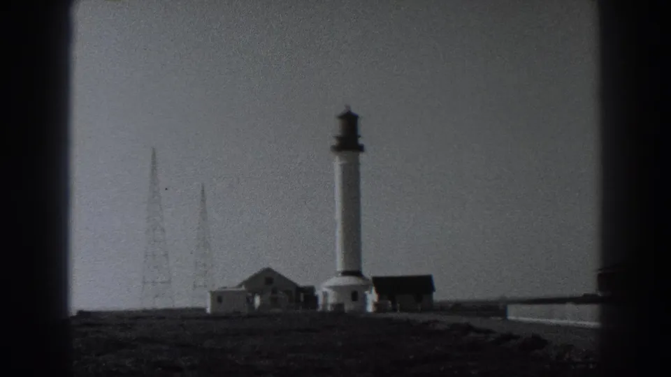 1938 Fort Ross view with the white lighthouse tower, low structures, radio masts, and open coastal ground.