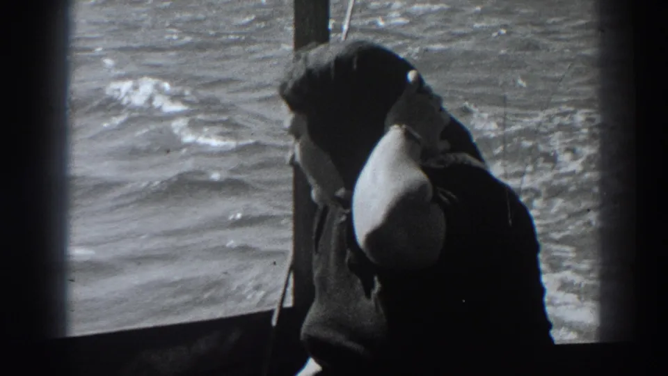 In 1938 Fort Ross, California home-movie footage, a woman sits beside a boat window as churning water passes outside.