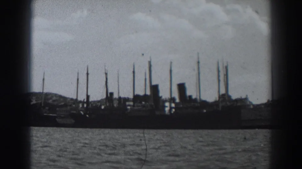 1938 8mm frame near Fort Ross with ship silhouettes and masts viewed from across the water.