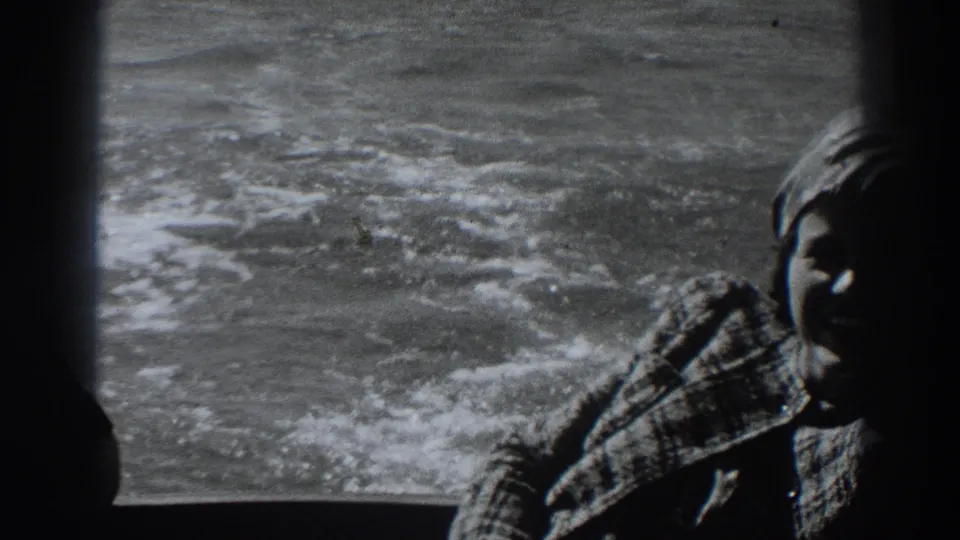 1938 8mm boat view near Fort Ross showing churning wake and a partially visible woman in a patterned coat and headscarf.