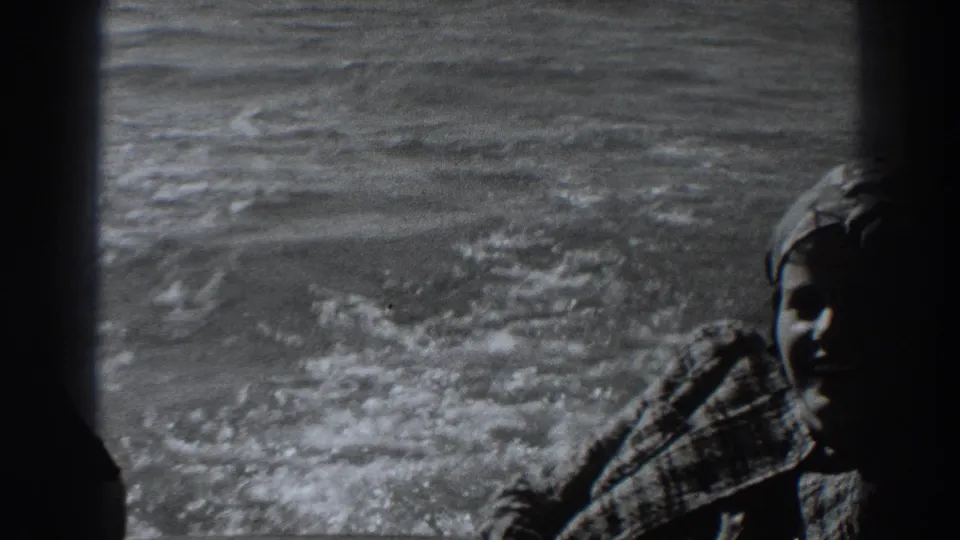 At the end of the clip, the woman remains beside the boat window while choppy water and wake continue across the background.