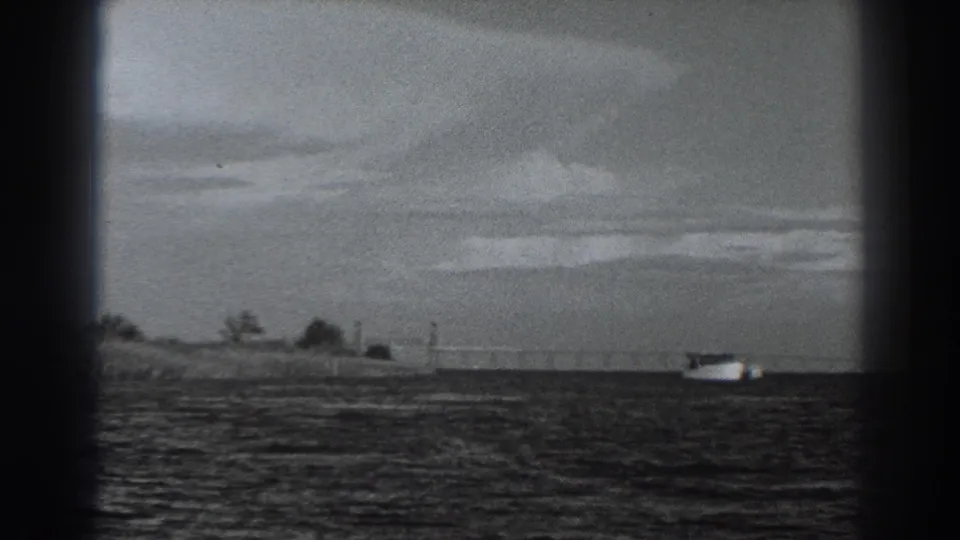 Final frame shows the same distant white boat and low shoreline in soft, vignetted Fort Ross-area 8mm footage.