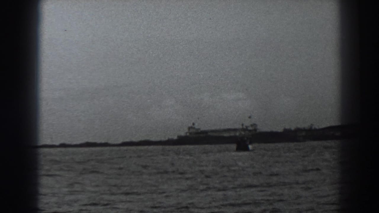 Wide water view with distant shoreline structures and a small dark object near center.