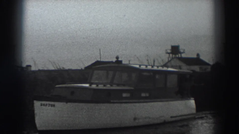 The final frame shows the cabin motorboat alongside the bank, with a visible bow marking and small shoreline structures in the distance.