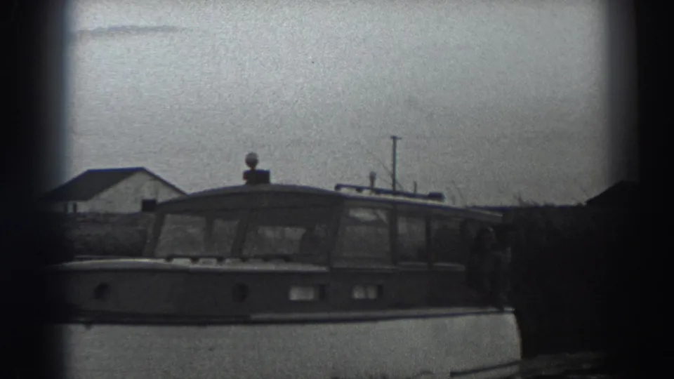 The final frame shows the Fort Ross cabin motorboat continuing along calm water beside a low building and shoreline vegetation.
