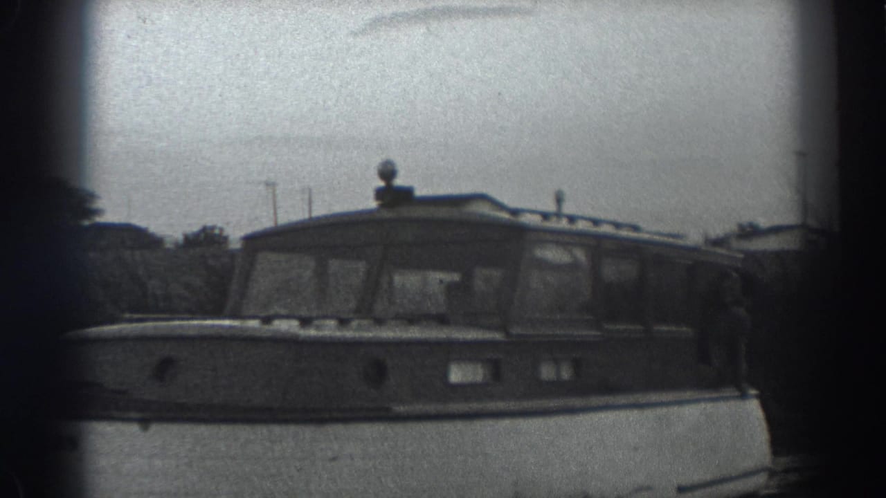 Motorboat seen closer from the side with a person near the stern area.