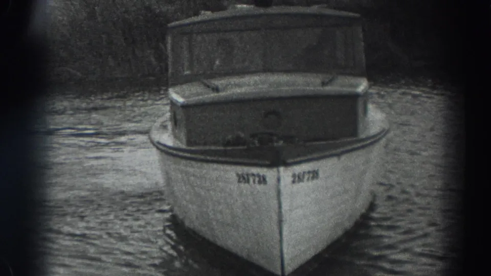 1938 Fort Ross frame with the bow of a small white cabin motorboat centered on calm, rippled water.
