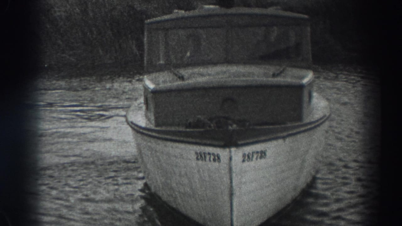 Small cabin motorboat facing the camera on rippled water.