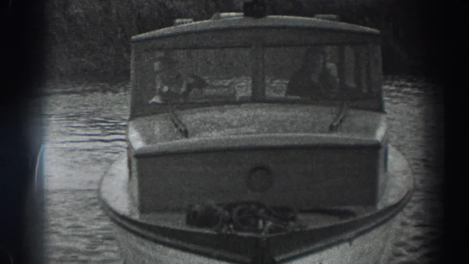 1938 Fort Ross home-movie frame with the cabin boat close to camera and possible occupants visible through the windows.