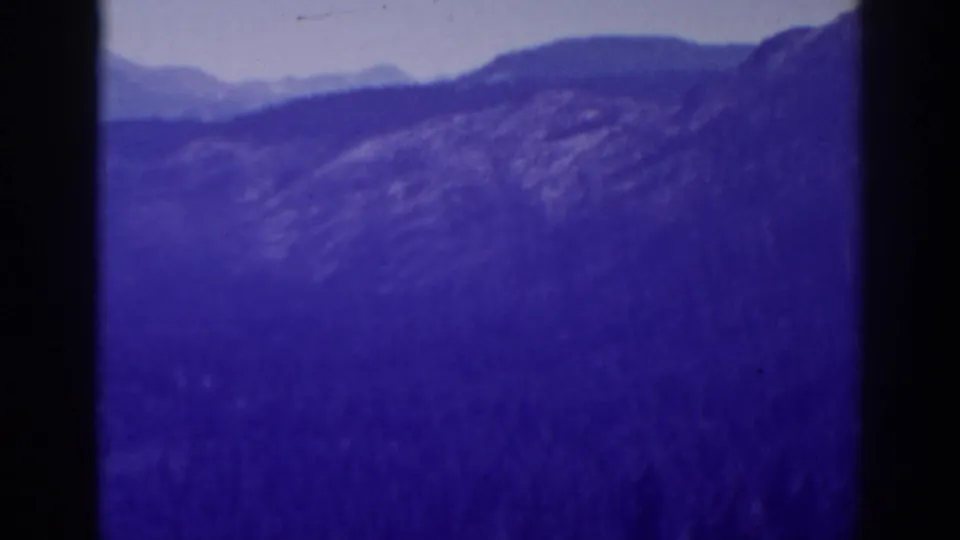 High Sierra ridges, likely near Lake Tahoe, appear in a soft 1938 8mm scenic travel shot with heavy color shift.