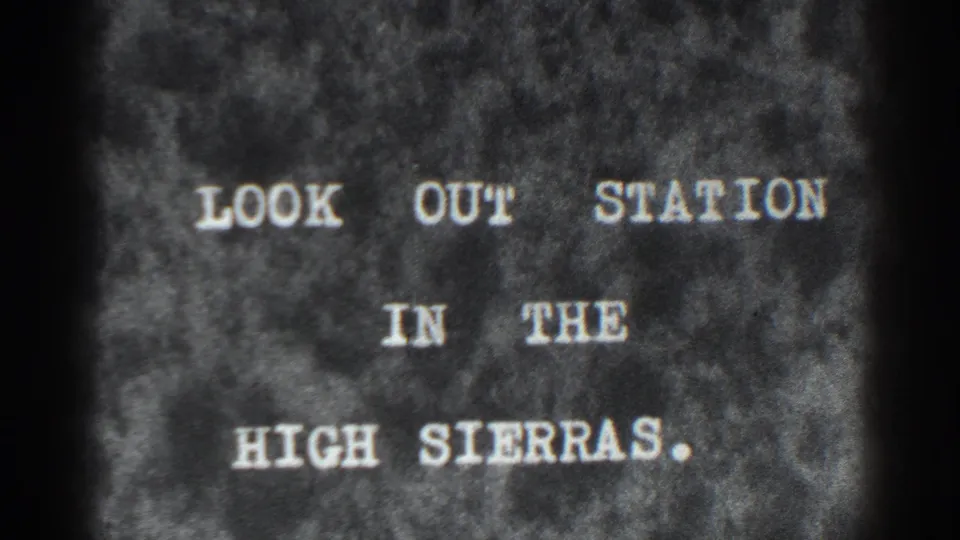 The 1938 8mm sequence holds on a title card reading LOOK OUT STATION IN THE HIGH SIERRAS, framed by dark film edges.